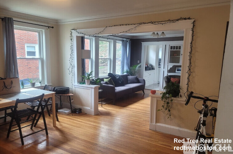 A living room with a dining table and chairs.