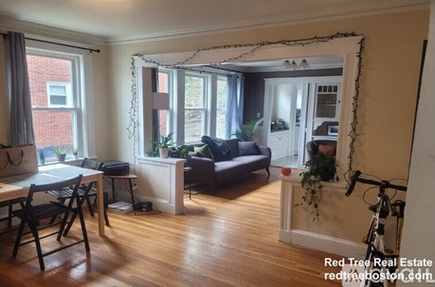 A living room with a dining table and chairs.