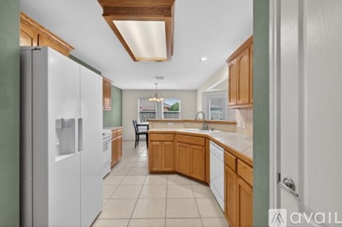 A kitchen with wooden cabinets and a white refrigerator.