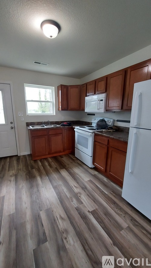 A kitchen with wooden cabinets and a white fridge.