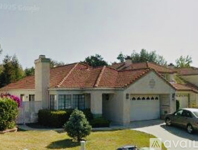 A house with a red tile roof and a car parked in front.