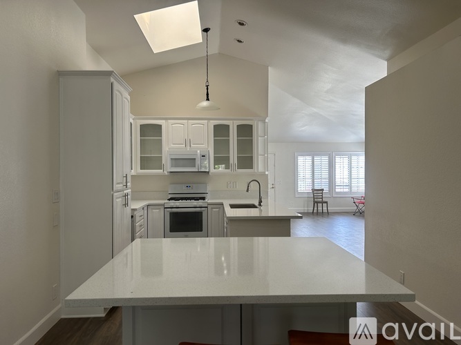 A modern kitchen with white cabinets and appliances.