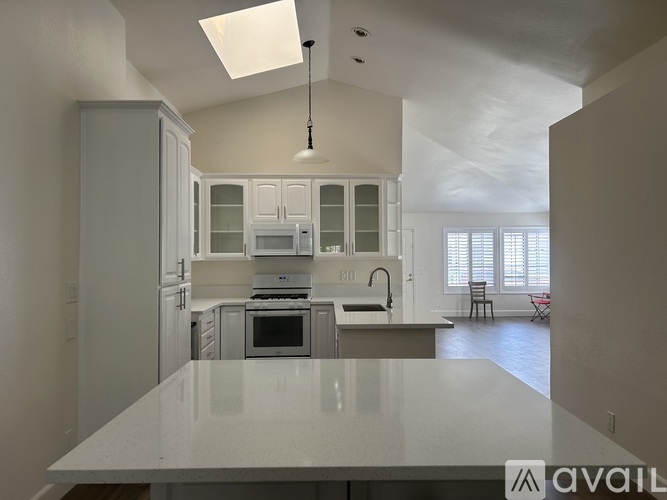 A modern kitchen with white cabinets and appliances.