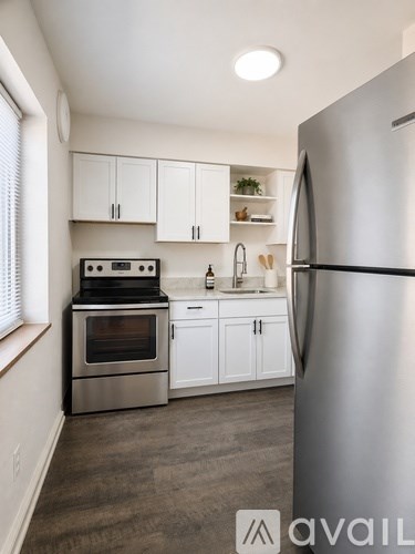 A kitchen with a stainless steel refrigerator, oven, and cabinets.