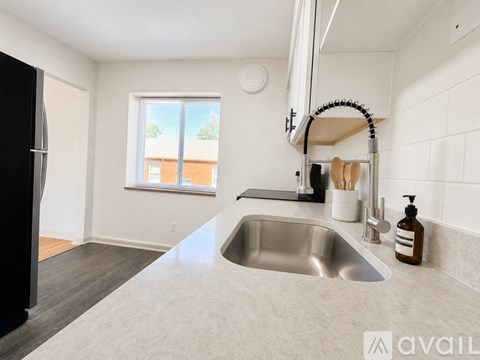 A modern kitchen with a stainless steel sink and a window.