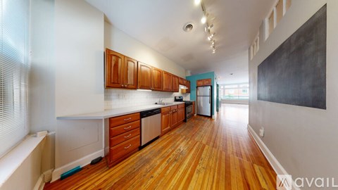 A kitchen with wooden floors and white countertops.