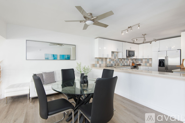 A modern dining room with a glass table and chairs.