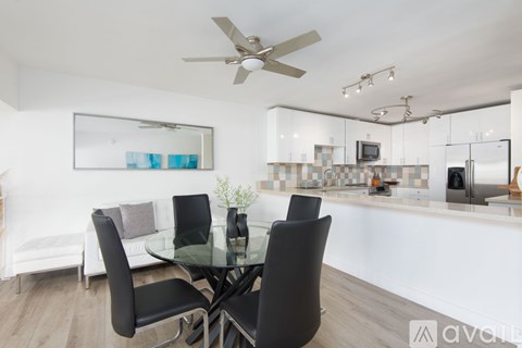 A modern dining room with a glass table and chairs.