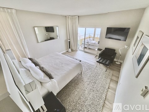 A bedroom with a large bed and a balcony.