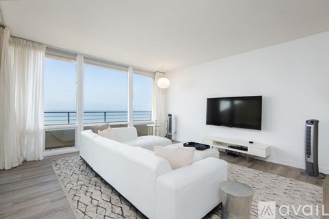 A living room with a large white sofa and a flat screen TV.