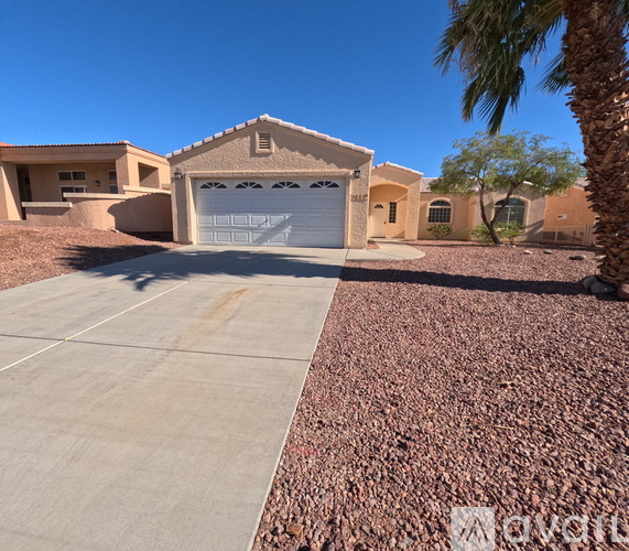 A house with a garage and driveway in front of it.