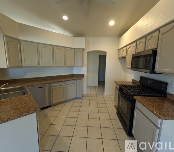A kitchen with white cabinets and a black stove top oven.