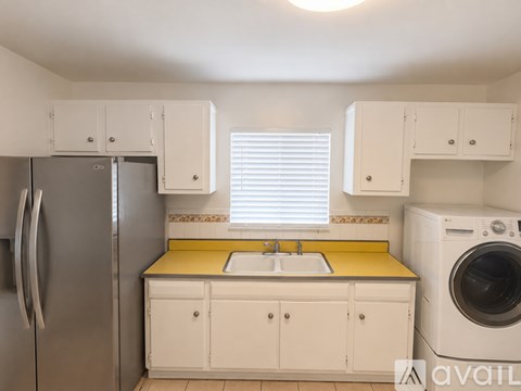 A kitchen with white cabinets and a yellow countertop.