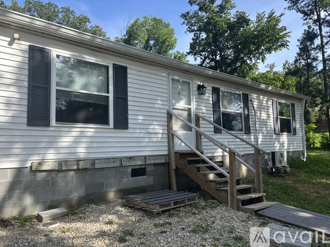 A mobile home with a staircase leading to the front door.
