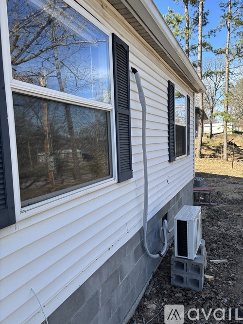 A house with a window and a grey electrical box outside.