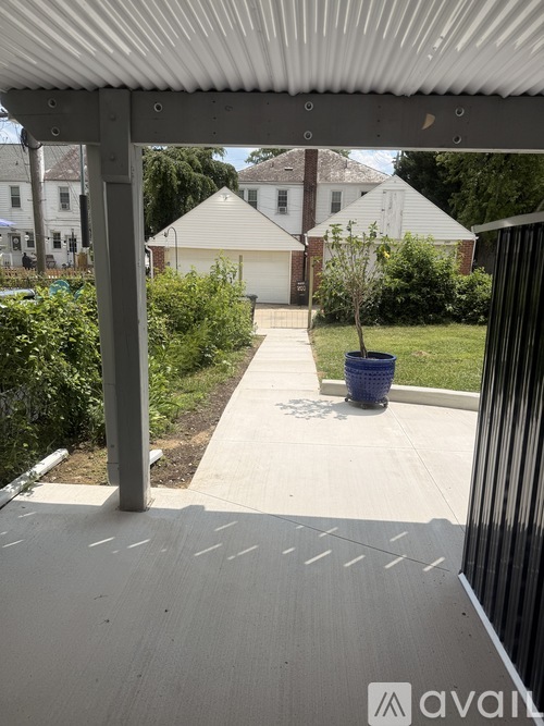 A white house with a grey roof and a white fence.
