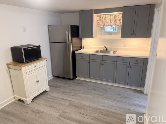 A kitchen with a refrigerator, microwave, and sink.