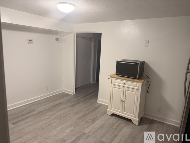 A room with a television on a cabinet and a door in the background.