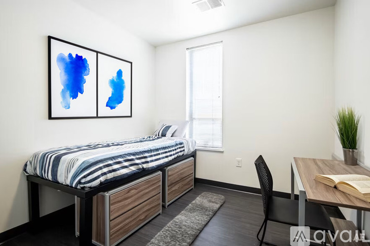 A bedroom with a bed, desk, and chair.