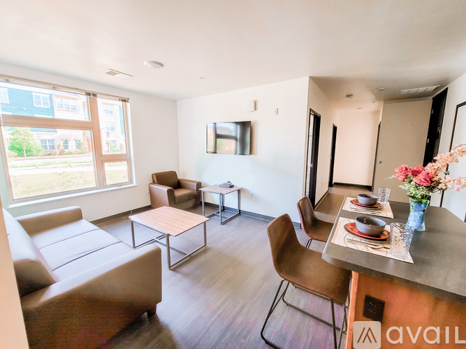 A living room with a couch, chairs, and a dining table.