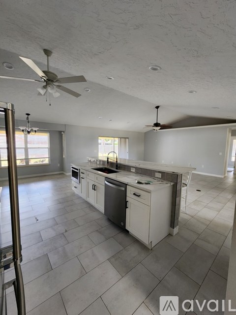 A kitchen with white cabinets and a white dishwasher.