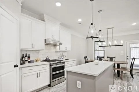 A modern kitchen with white cabinets and a central island.