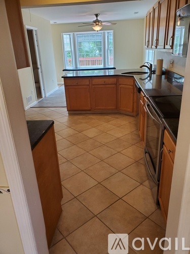 A kitchen with brown cabinets and black countertops.