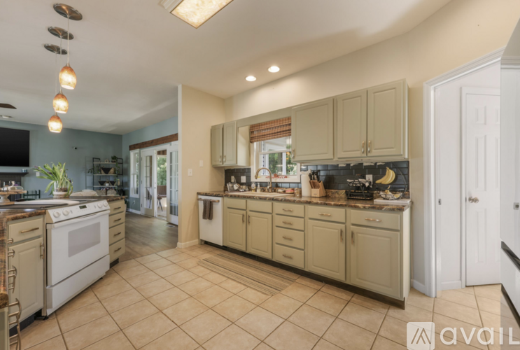 A kitchen with a white stove and cabinets.