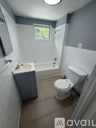 A bathroom with a toilet, sink, and bathtub.