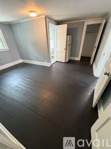A room with a wooden floor and a white door.