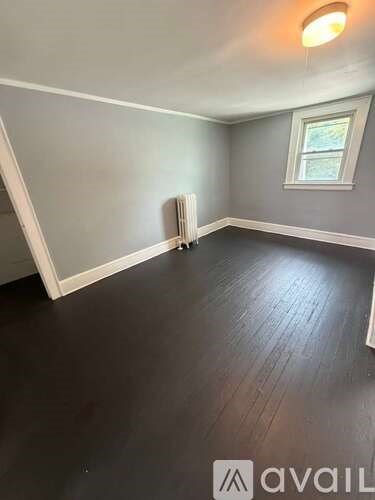 A room with a window and a radiator on the wall.