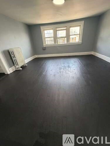 A room with a window and a radiator on the floor.