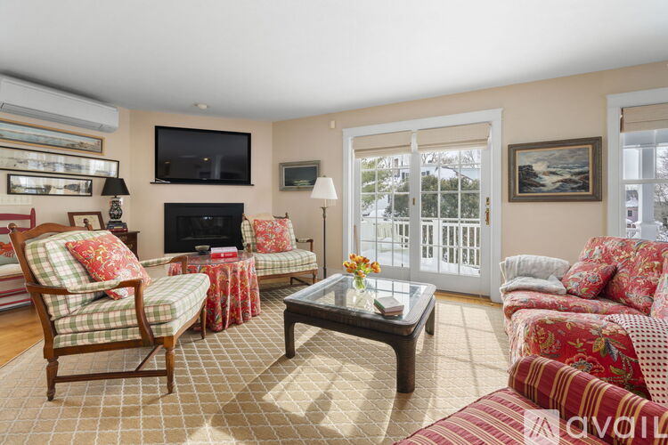 A living room with a fireplace and a television on the wall.