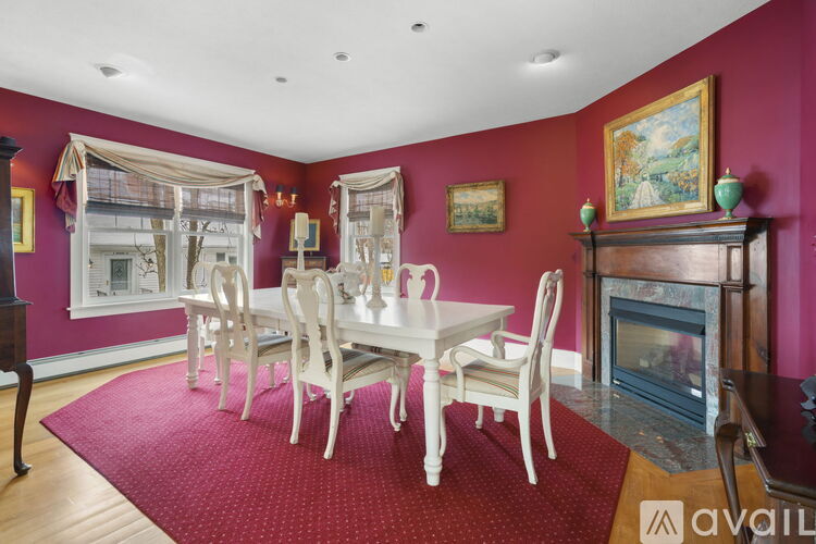 A dining room with a white table and chairs.