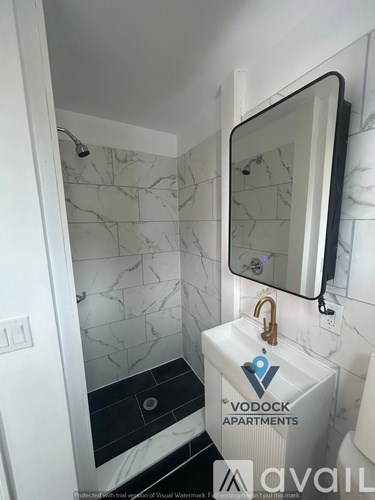 A bathroom with a marble tile wall and a white sink.