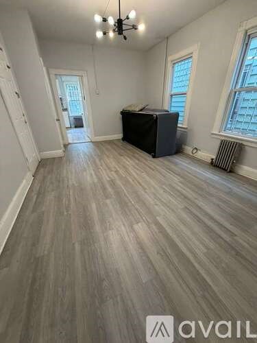 A room with wooden flooring and a chandelier.