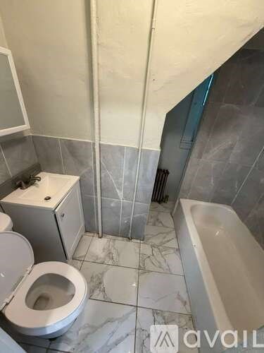 A bathroom with a toilet, sink, and bathtub.