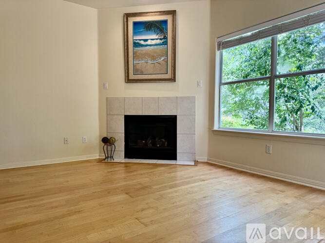 A living room with a fireplace and a painting above it.