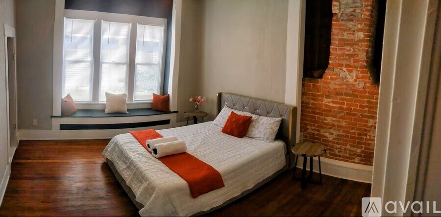A bedroom with a large bed and a window seat.