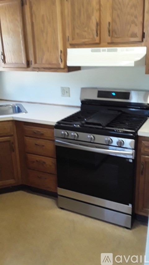 A black stove top oven in a kitchen with wooden cabinets.