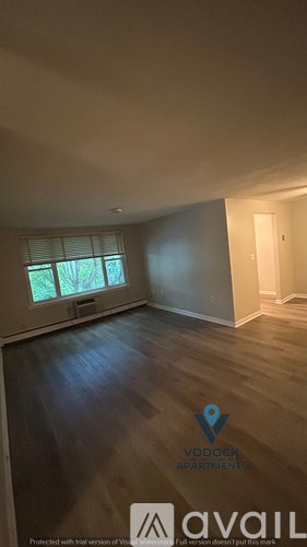 A Vodochk Apartments listing shows a large empty room with wood floors and a window.