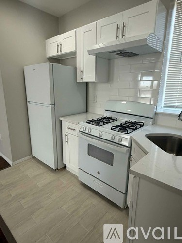 A kitchen with a white stove and cabinets.