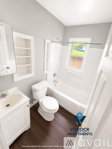 A white bathroom with a toilet, sink, and bathtub.