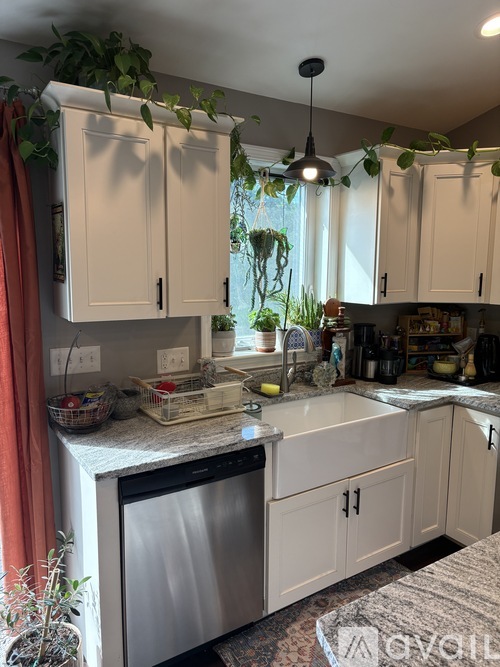 A kitchen with white cabinets and a stainless steel dishwasher.