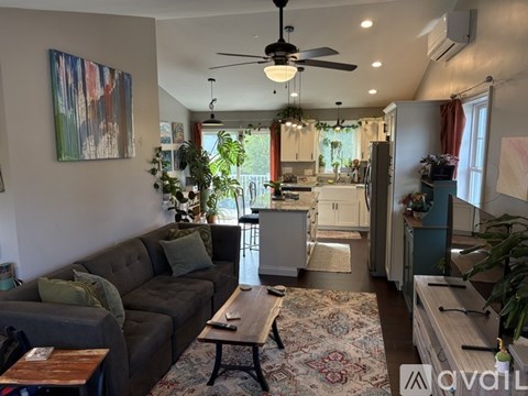 A living room with a grey couch and a rug on the floor.