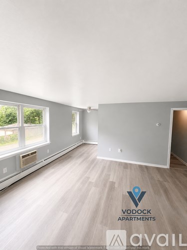 A room with a window and a wooden floor is available for rent.