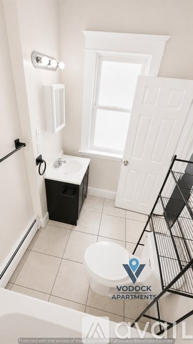 A bathroom with a toilet, sink, and window.