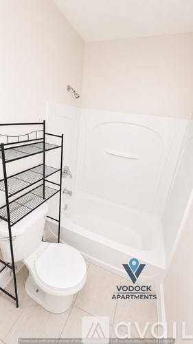 A bathroom with a toilet, bathtub, and a shelf.