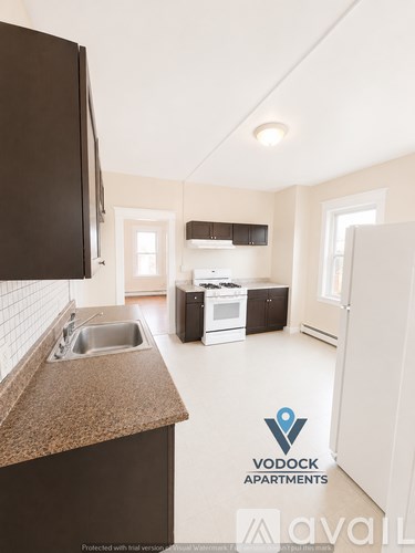 A kitchen with a sink and a refrigerator.