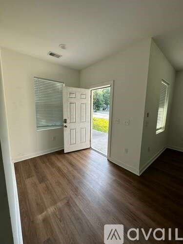 A room with wooden floors and a door leading outside.